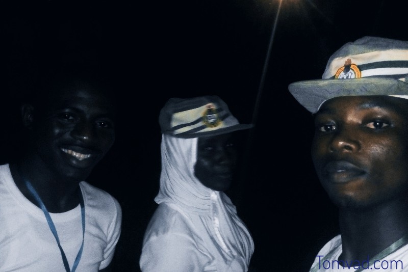 three corps member enjoying the camp at night